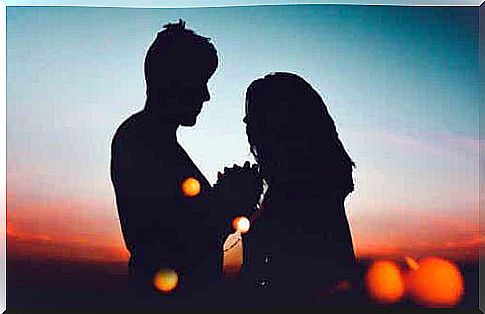 A man and a woman as silhouettes against sunset