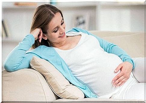 Pregnant woman looking at belly