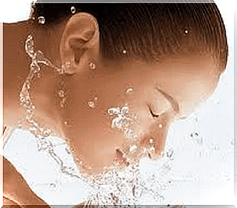 woman washes face with water