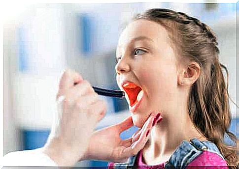 The doctor examines the throat to diagnose pharyngotonsillitis