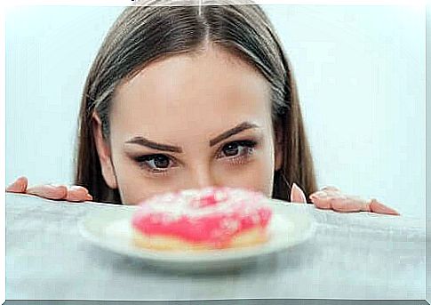 Woman stares at donut and the differences between hunger and fear