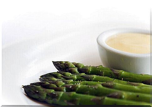 Asparagus with a bowl of cream