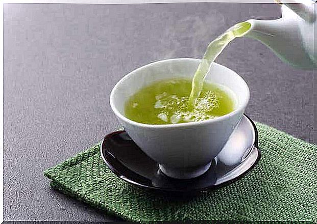 Someone pours a cup of green tea